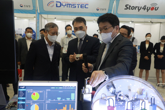 이종욱(가운데) 조달청장이 10일 대전컨벤션센터에서 열린 '혁신제품 권역별 순회 전시회'에서 시설물 보안과 안전을 위한 '스마트 자물쇠'에 대해 설명을 듣고 있다.  조달청 제공